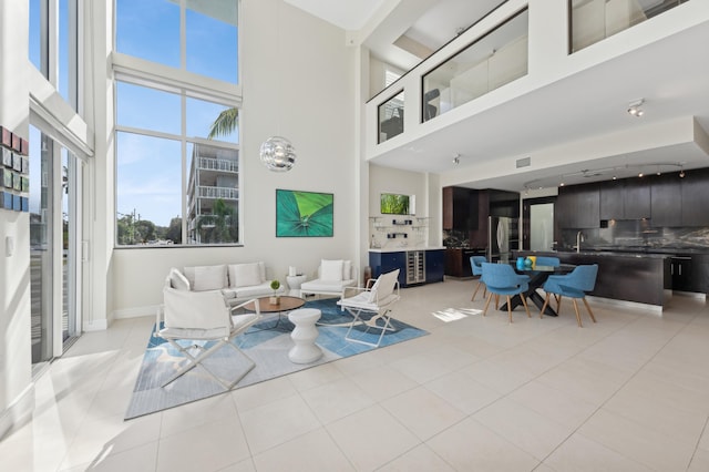 tiled living room with a towering ceiling and sink