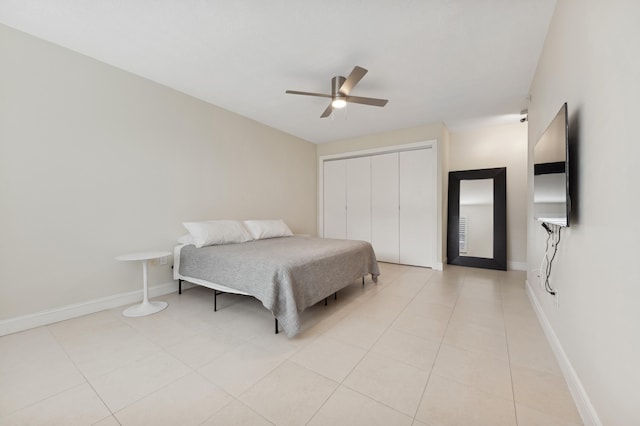 bedroom featuring ceiling fan, a closet, and light tile patterned flooring