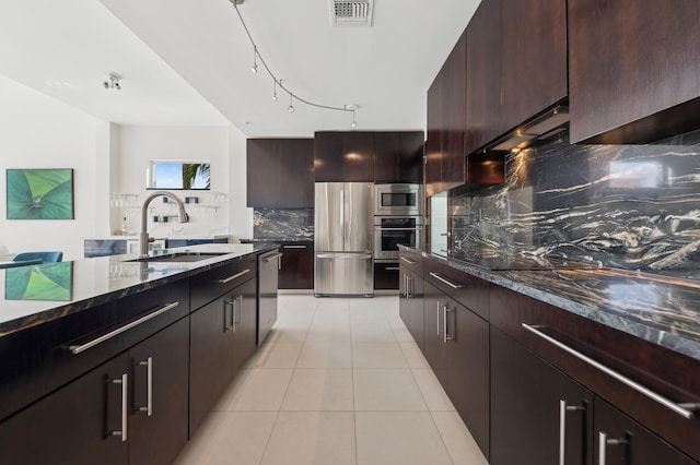 kitchen with backsplash, dark brown cabinetry, sink, and appliances with stainless steel finishes