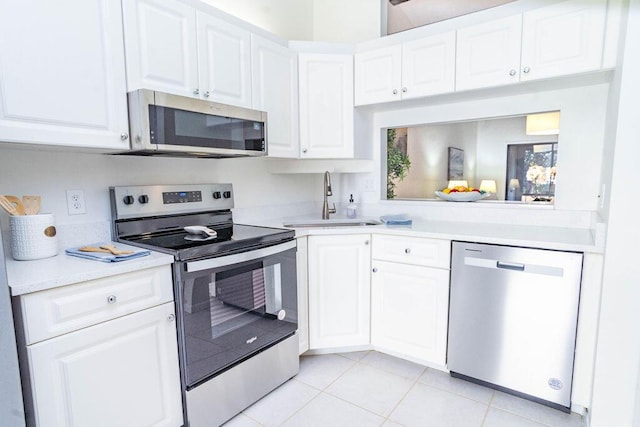 kitchen with white cabinetry, sink, light tile patterned floors, and stainless steel appliances