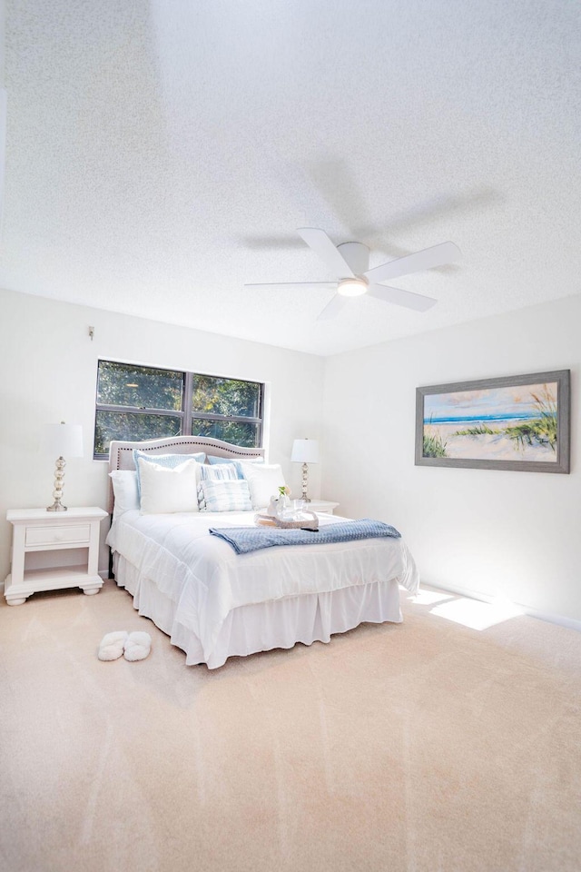 carpeted bedroom featuring a textured ceiling and ceiling fan