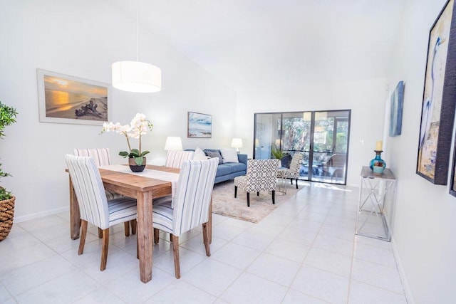 tiled dining space featuring high vaulted ceiling