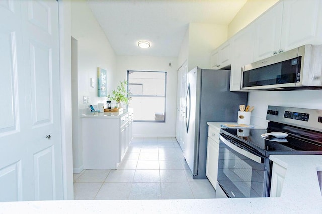 kitchen featuring light stone counters, white cabinetry, stainless steel appliances, and light tile patterned floors