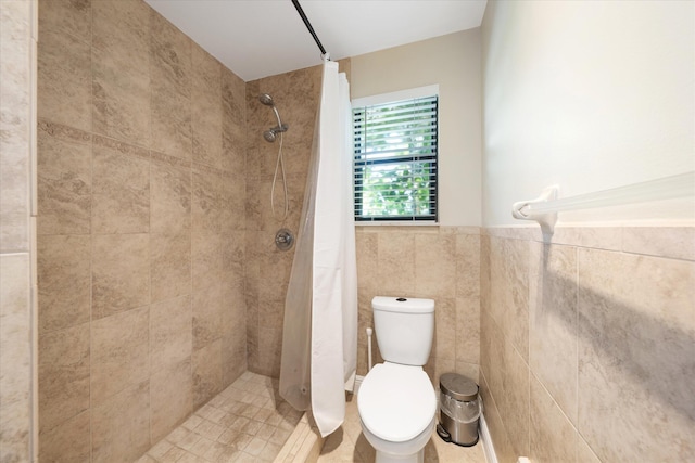 bathroom with toilet, curtained shower, and tile walls