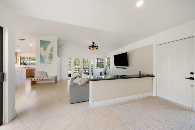 living room with a healthy amount of sunlight, lofted ceiling, and light tile patterned floors