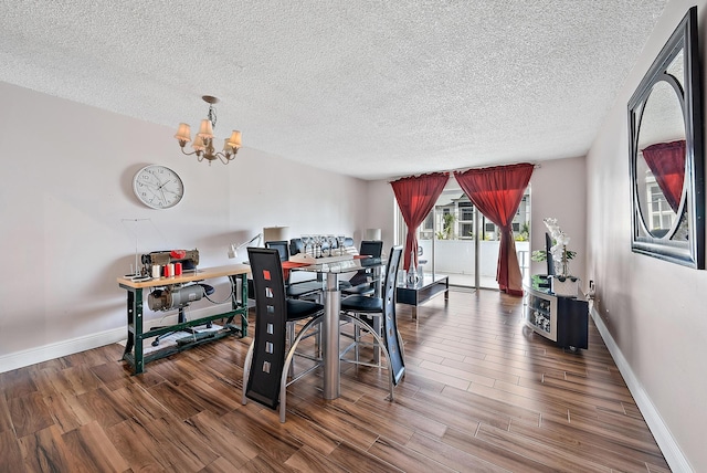 dining space featuring an inviting chandelier, a textured ceiling, and hardwood / wood-style flooring