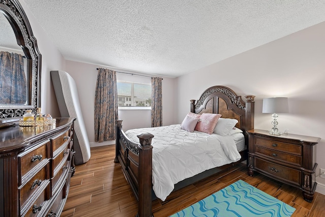 bedroom with dark hardwood / wood-style flooring and a textured ceiling