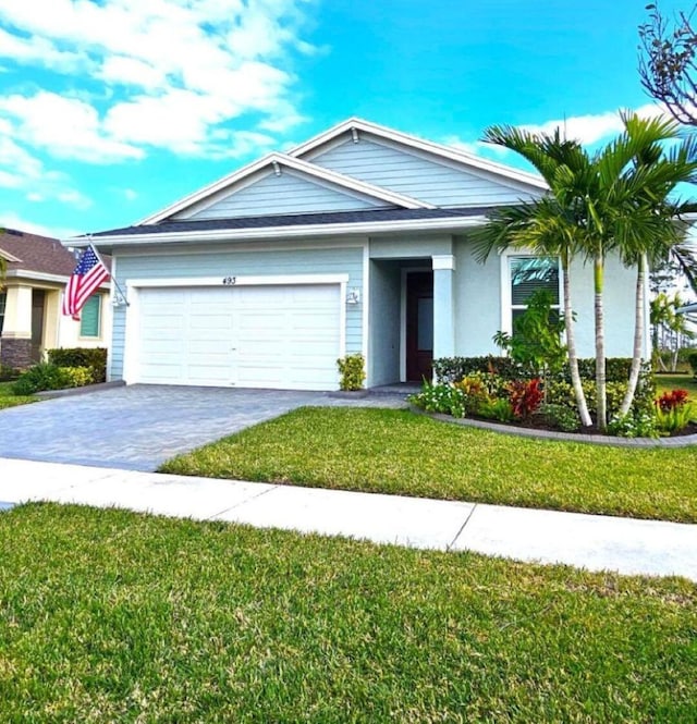 single story home featuring a front yard and a garage