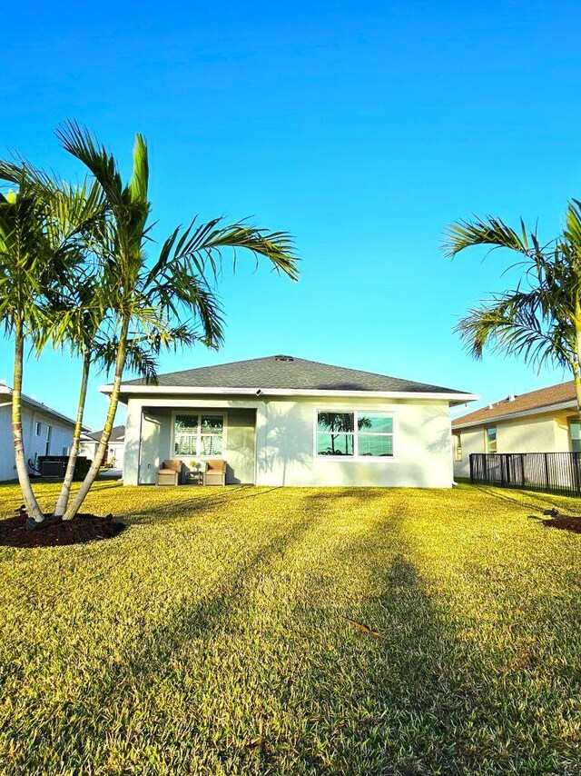 rear view of house featuring a yard