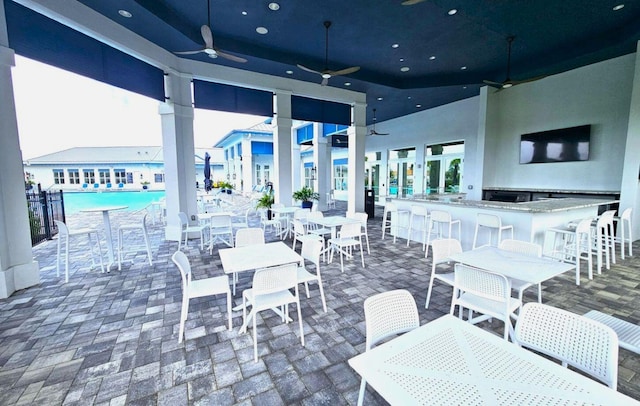 view of patio featuring a bar and ceiling fan