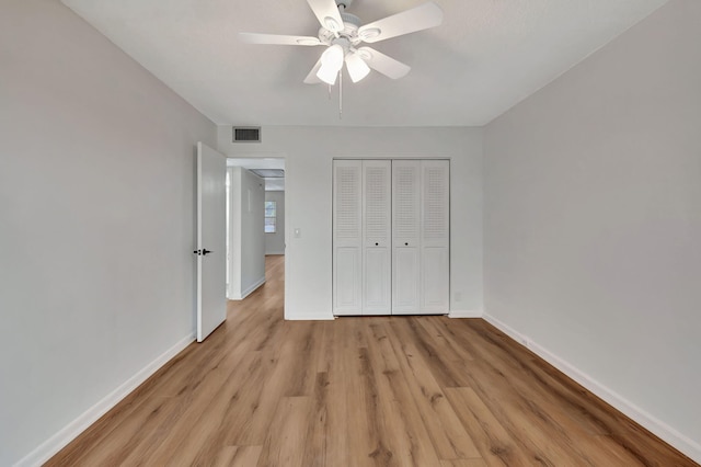 unfurnished bedroom with ceiling fan, light hardwood / wood-style floors, and a closet