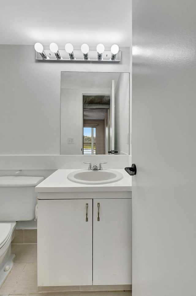 bathroom with tile patterned flooring, vanity, and toilet