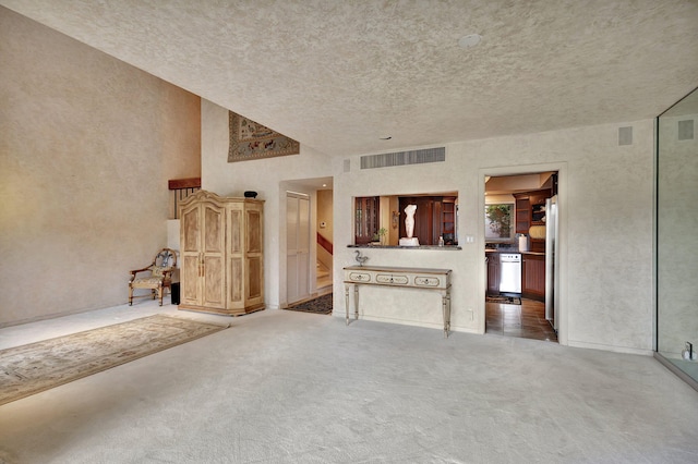 unfurnished living room with carpet flooring and a textured ceiling