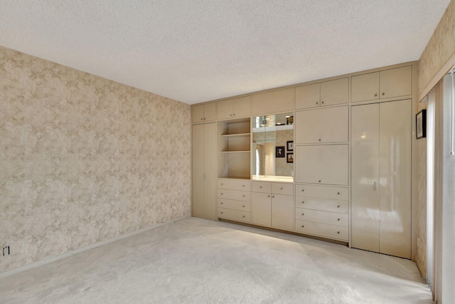 unfurnished bedroom featuring a textured ceiling, light carpet, and a closet