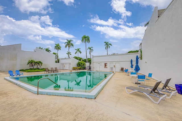 view of swimming pool featuring a patio and an outdoor structure