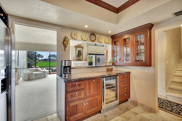 kitchen featuring dark stone counters, wine cooler, a wealth of natural light, and light colored carpet