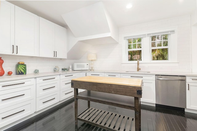 kitchen with white cabinets, backsplash, stainless steel dishwasher, and sink