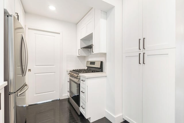 kitchen featuring decorative backsplash, dark hardwood / wood-style flooring, white cabinetry, and stainless steel appliances