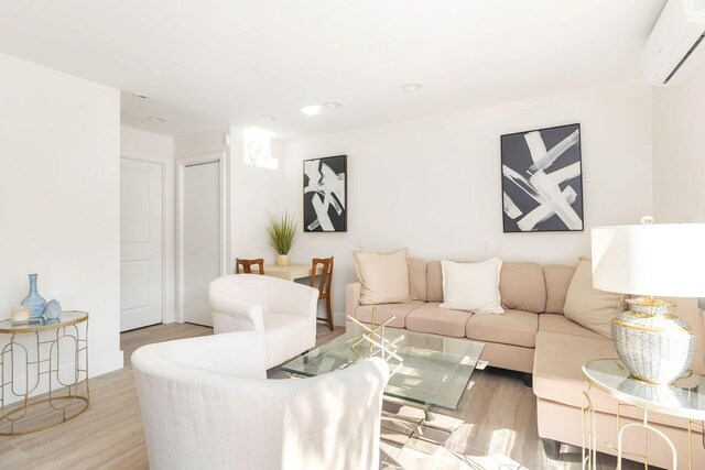 living room featuring an AC wall unit and light wood-type flooring