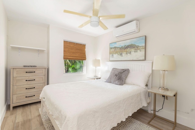 bedroom with light hardwood / wood-style flooring, an AC wall unit, and ceiling fan