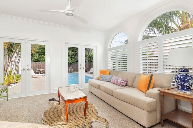 carpeted living room featuring crown molding, french doors, and ceiling fan