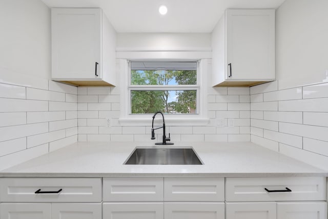 kitchen featuring white cabinets, tasteful backsplash, and sink