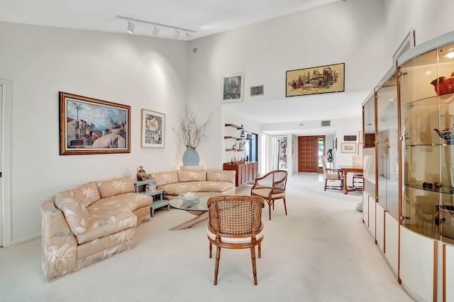 living room with light colored carpet and rail lighting