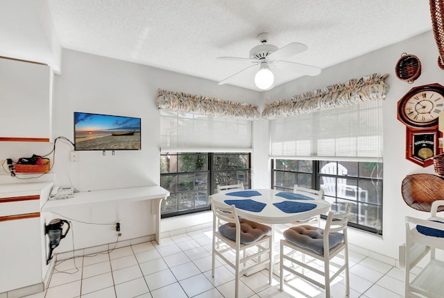 tiled dining space with ceiling fan and a textured ceiling