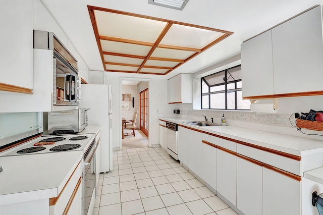 kitchen featuring light tile patterned floors, white appliances, white cabinetry, and sink