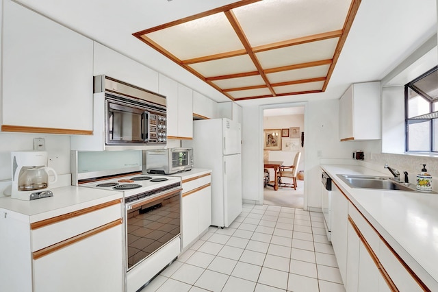 kitchen with white cabinets, light tile patterned floors, white appliances, and sink