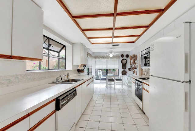 kitchen featuring light tile patterned flooring, white appliances, white cabinetry, and sink