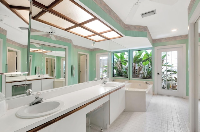 bathroom with tile patterned floors, a tub, and vanity