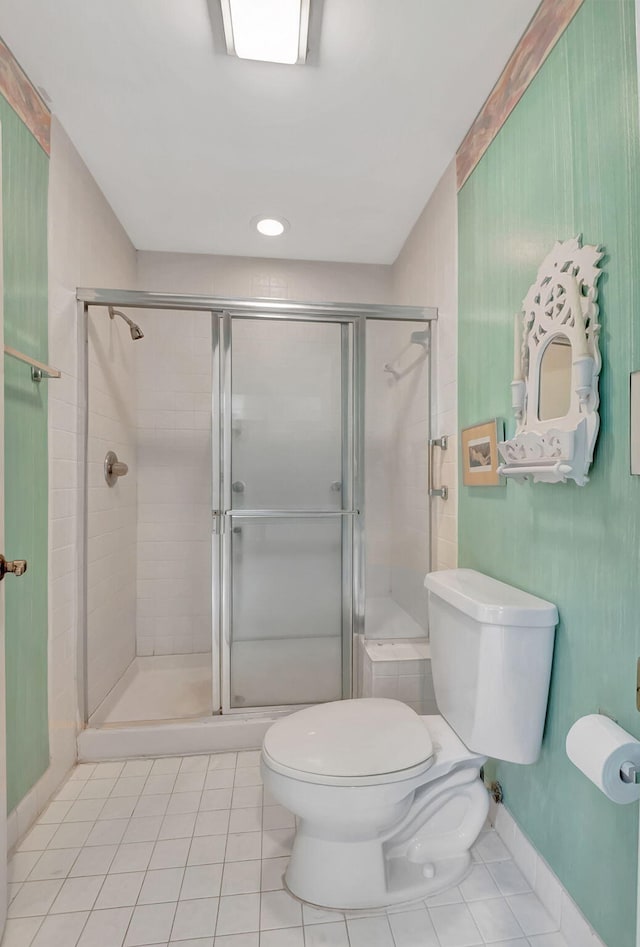 bathroom featuring tile patterned floors, toilet, and an enclosed shower