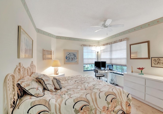 carpeted bedroom featuring a textured ceiling and ceiling fan