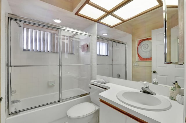 full bathroom with vanity, enclosed tub / shower combo, and toilet