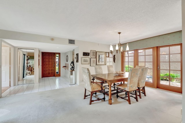 dining space with light colored carpet, a textured ceiling, and a notable chandelier