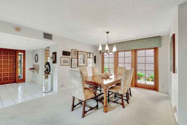 carpeted dining space with french doors, a textured ceiling, and an inviting chandelier