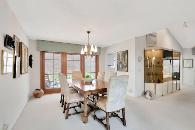 dining area featuring light carpet and a chandelier