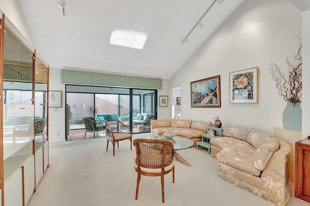 carpeted living room with rail lighting and vaulted ceiling