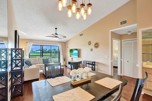 dining room with dark hardwood / wood-style flooring, ceiling fan with notable chandelier, a textured ceiling, and high vaulted ceiling