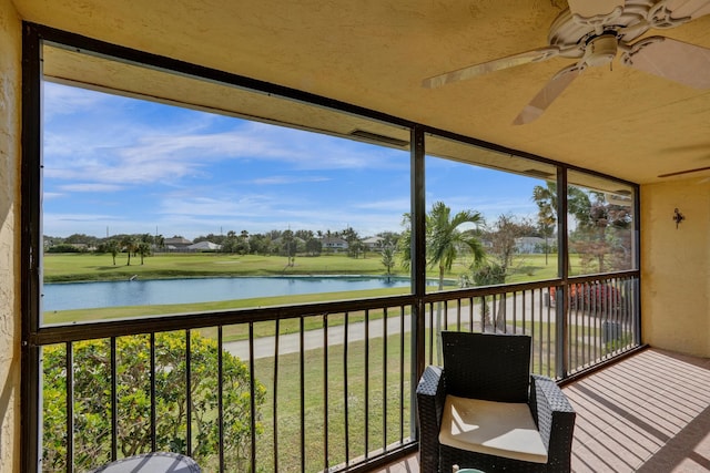 unfurnished sunroom with ceiling fan and a water view