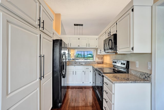 kitchen featuring dark hardwood / wood-style flooring, white cabinets, black appliances, and sink