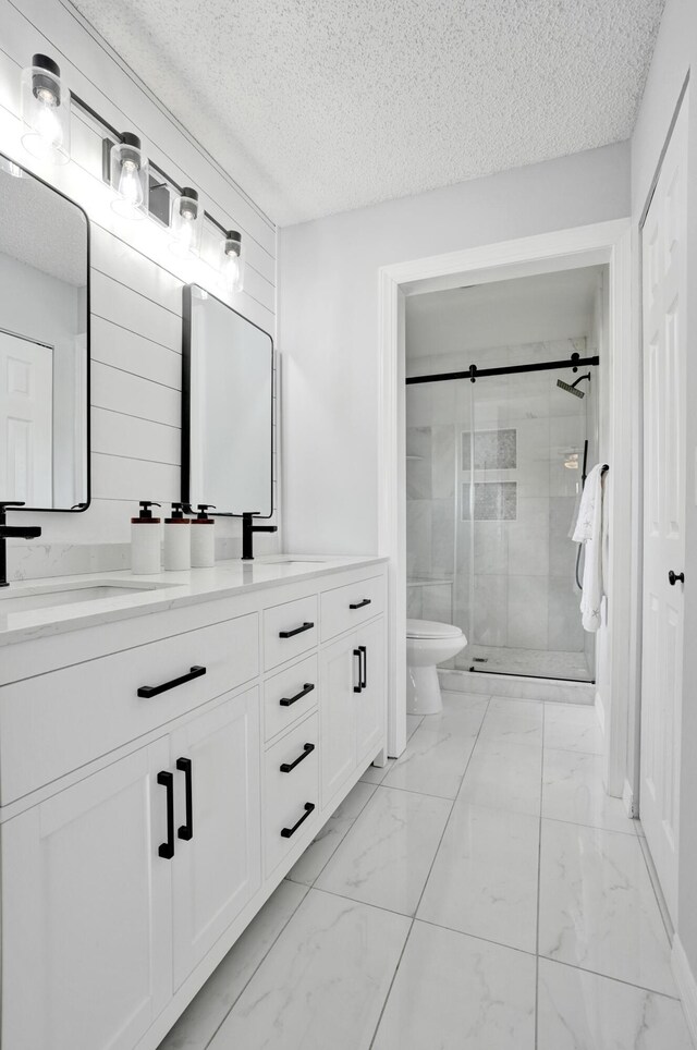 bathroom with vanity, a textured ceiling, toilet, and walk in shower