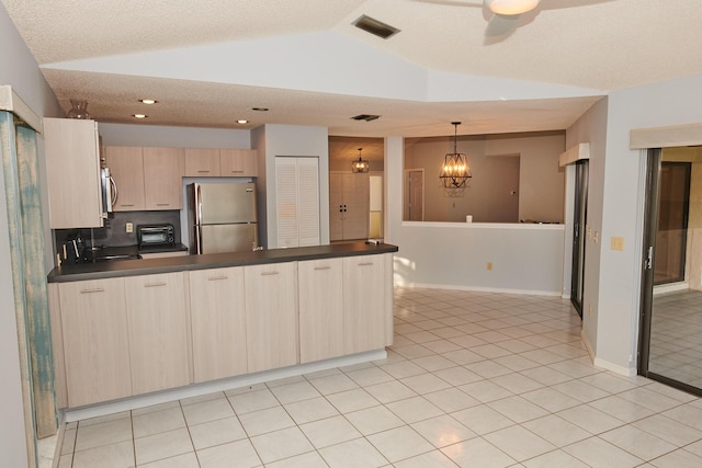 kitchen featuring decorative backsplash, light brown cabinets, vaulted ceiling, and appliances with stainless steel finishes