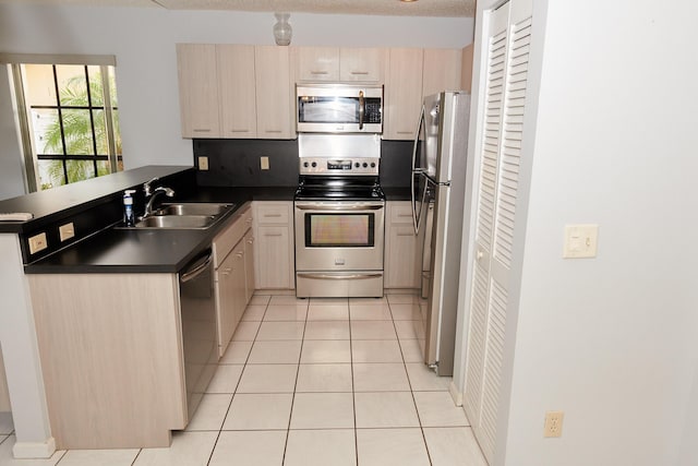 kitchen featuring sink, light brown cabinets, stainless steel appliances, kitchen peninsula, and light tile patterned floors