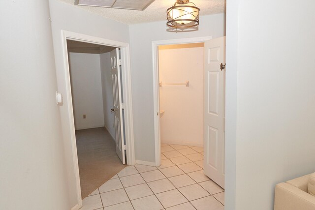 hallway featuring light carpet and a textured ceiling