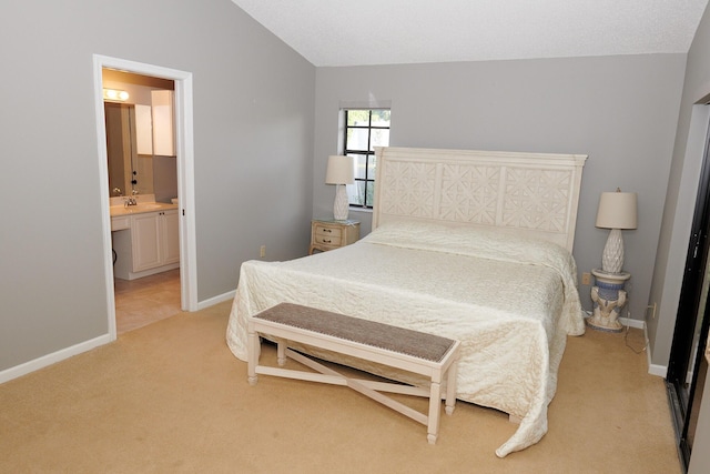 bedroom featuring light colored carpet, sink, connected bathroom, and vaulted ceiling