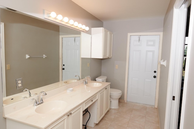 bathroom with tile patterned flooring, vanity, and toilet