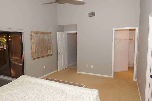 unfurnished bedroom with ceiling fan, a walk in closet, carpet floors, and a closet