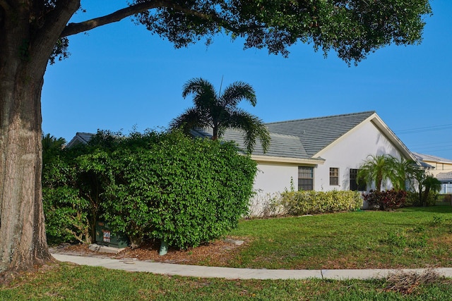 view of side of home with a lawn